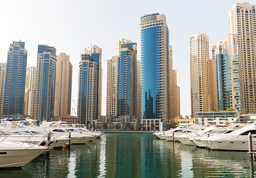 cityscape, travel, tourism and urban concept - Dubai city seafront or harbor with boats