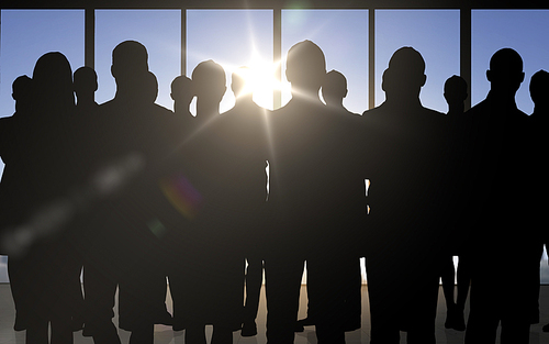 business, teamwork and people concept - business people silhouettes over office background