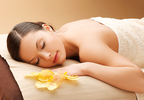 spa and beauty concept - woman in spa salon lying on the massage desk