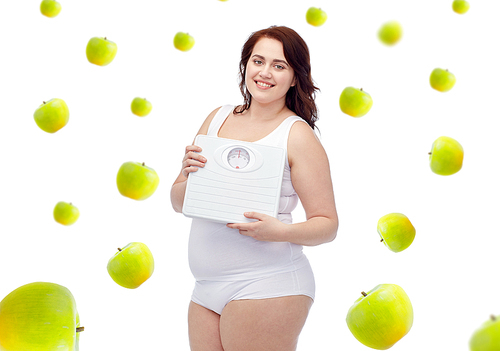 weight loss, diet, slimming, healthy eating and people concept - happy young plus size woman in underwear holding scales over green apples background