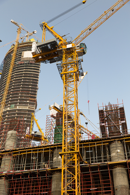 construction, development, architecture, industry and engineering concept - building of skyscraper in Dubai city