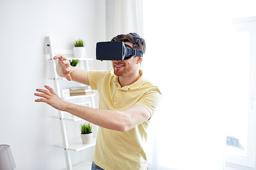 technology, gaming, entertainment and people concept - happy young man with virtual reality headset or 3d glasses playing video game