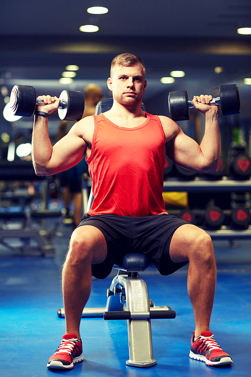 sport, fitness, bodybuilding, lifestyle and people concept - young man with dumbbells flexing muscles in gym