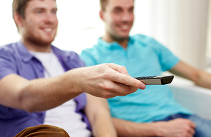 friendship, sports, people and entertainment concept - close up of happy male friends with remote control watching tv at home