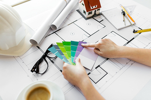business, architecture, building, construction and people concept - close up of designer hands with color palette and blueprint