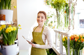 people, business, technology, sale and floristry and concept - happy smiling florist woman with tablet pc computer at flower shop