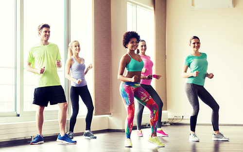 fitness, sport, dance and lifestyle concept - group of smiling people with coach dancing in gym or studio