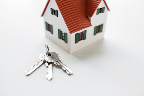 architecture, building, mortgage, real estate and property concept - close up of home model and house keys