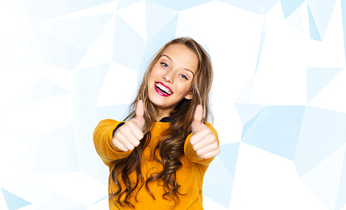 people, gesture, style and fashion concept - happy young woman or teen girl in casual clothes showing thumbs up over low poly blue background