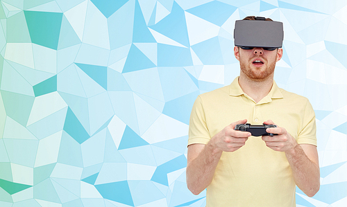 3d technology, virtual reality, entertainment and people concept - happy young man with virtual reality headset or 3d glasses playing with game controller gamepad over low poly background