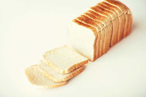 food, junk-food and unhealthy eating concept - close up of white sliced toast bread on table