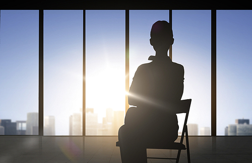 business and people concept - silhouette of woman sitting on chair over office window background