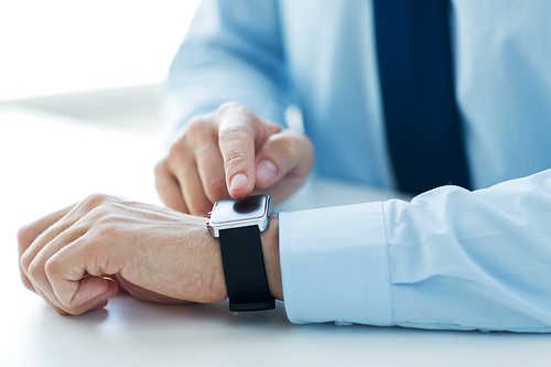 business, technology and people concept - close up of male hands setting smart watch at home