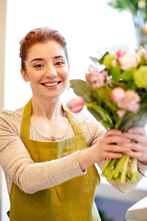 people, business,  and floristry concept - happy smiling florist woman making bunch at flower shop