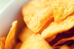 food, junk-food, cuisine and eating concept - close up of corn crisps or nachos in bowl