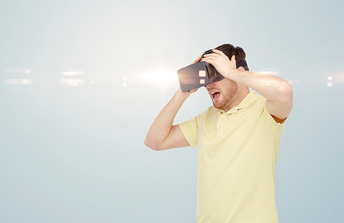 3d technology, virtual reality, entertainment and people concept - happy young man with virtual reality headset or 3d glasses playing game over gray background