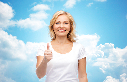 gesture, advertisement and people concept - smiling woman in blank white t-shirt showing thumbs up over blue sky and clouds background