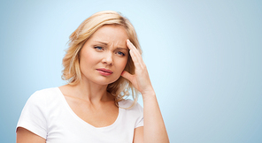 people, healthcare, stress and problem concept - unhappy woman suffering from headache over blue background