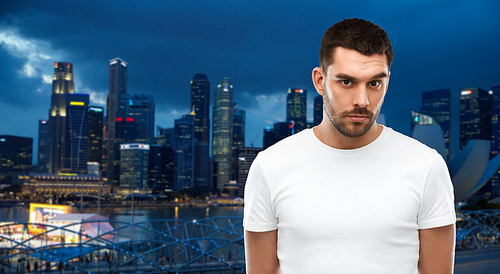 travel, tourism, people concept - young man portrait over night singapore city background