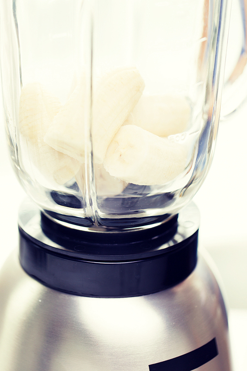 healthy eating, cooking, kitchen appliances and technology concept - close up of blender shaker with bananas