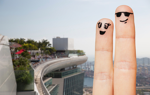 family, couple, travel, tourism and body parts concept - close up of two fingers with smiley faces over dubai city hotel background