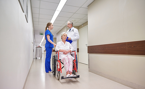 medicine, age, health care and people concept - doctor, nurse and senior woman patient in . at hospital corridor