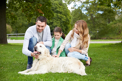 family, pet, domestic animal and people concept - happy family with labrador retriever dog on walk in park