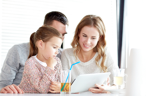 family, parenthood, technology and people concept - happy mother, father and little girl with tablet pc computer having dinner at restaurant