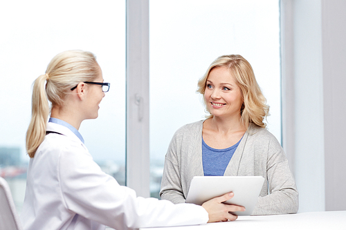 medicine, health care and people concept - smiling doctor with tablet pc computer and woman meeting at hospital