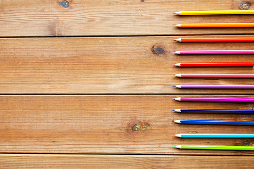 art, color, drawing, creativity and object concept - close up of crayons or color pencils on wooden table