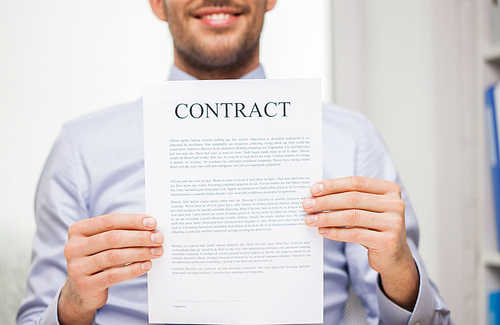 people, business and paperwork concept - close up of smiling businessman holding contract document