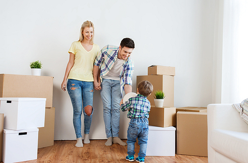 mortgage, people, housing, moving and real estate concept - happy family with boxes playing ball at new home