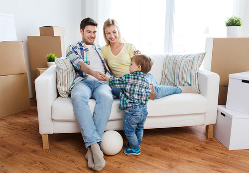 mortgage, people, housing, moving and real estate concept - happy family with boxes playing ball at new home