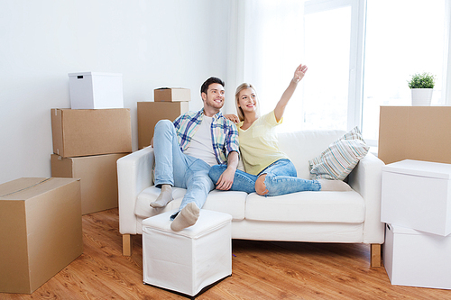 people, repair and real estate concept - smiling couple with boxes moving to new home and dreaming