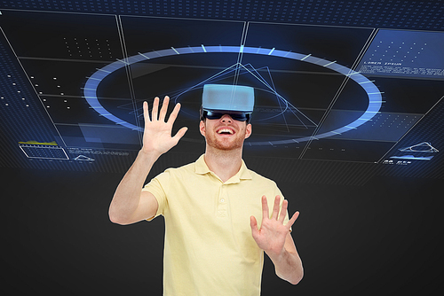 3d technology, virtual reality, entertainment and people concept - happy young man in virtual reality headset or 3d glasses playing game over black background with screens