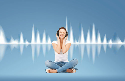 technology, music and happiness concept - smiling young woman or teen girl in headphones over blue background and sound wave or diagram