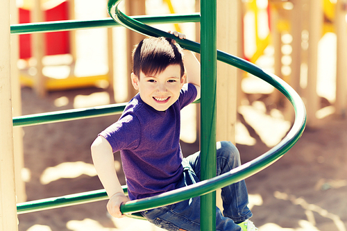 summer, childhood, leisure and people concept - happy little boy on children playground climbing frame