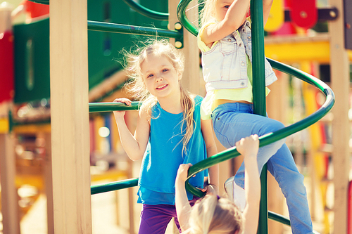 summer, childhood, leisure, friendship and people concept - group of happy kids on children playground climbing frame