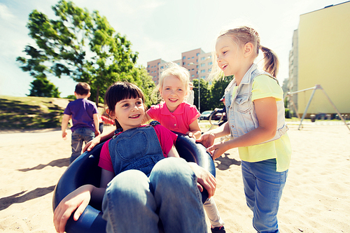 summer, childhood, leisure, friendship and people concept - happy kids on children playground climbing frame