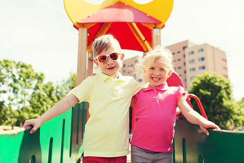 summer, childhood, leisure, friendship and people concept - two happy kids hugging on children playground