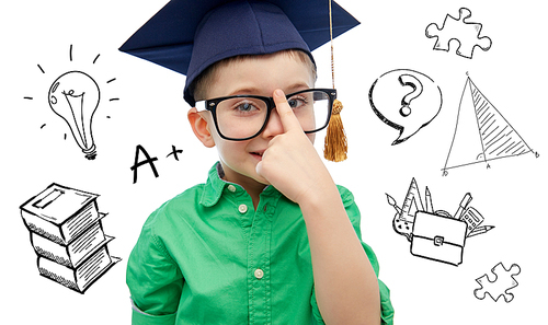 childhood, school, education, knowledge and people concept - happy boy in bachelor hat or mortarboard and eyeglasses over doodles