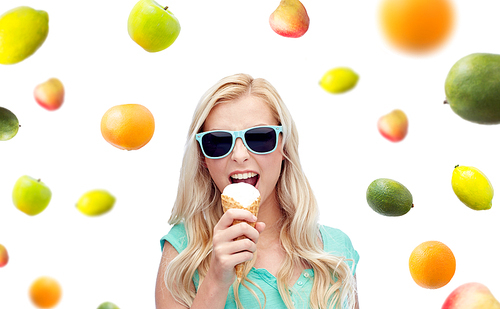 summer, junk food, healthy eating and people concept - young woman or teenage girl in sunglasses eating ice cream over fruits on white background