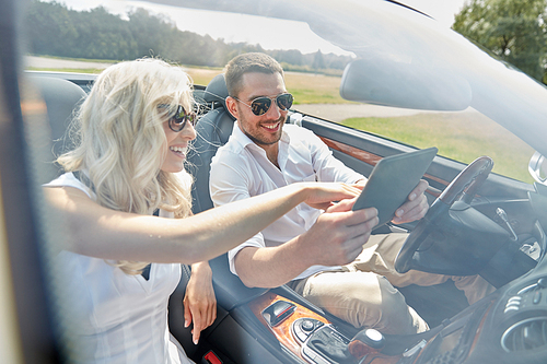 road trip, travel, summer vacation, technology and people concept - happy couple with tablet pc in cabriolet car