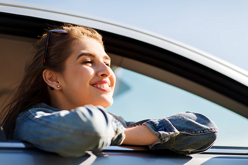 summer vacation, holidays, travel, road trip and people concept - happy smiling teenage girl or young woman in car