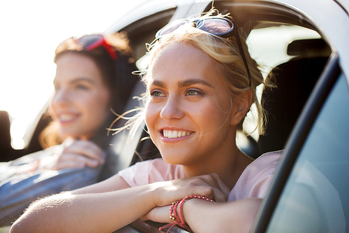 summer vacation, holidays, travel, road trip and people concept - happy teenage girls or young women in car at seaside