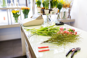 people, business,  and floristry concept - close up of floristic tools on flower shop counter