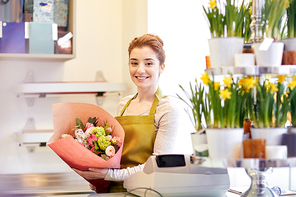 people, business,  and floristry concept - happy smiling florist woman holding bunch of flowers wrapped into paper at flower shop