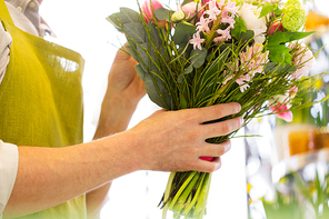 people, business,  and floristry concept - close up of florist man making bunch at flower shop