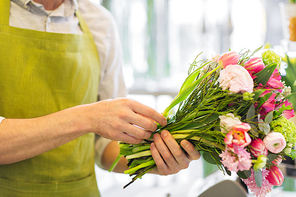 people, business,  and floristry concept - close up of florist man making bunch at flower shop