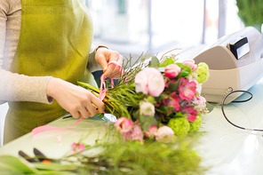 people, business,  and floristry concept - close up of florist woman making bunch at flower shop